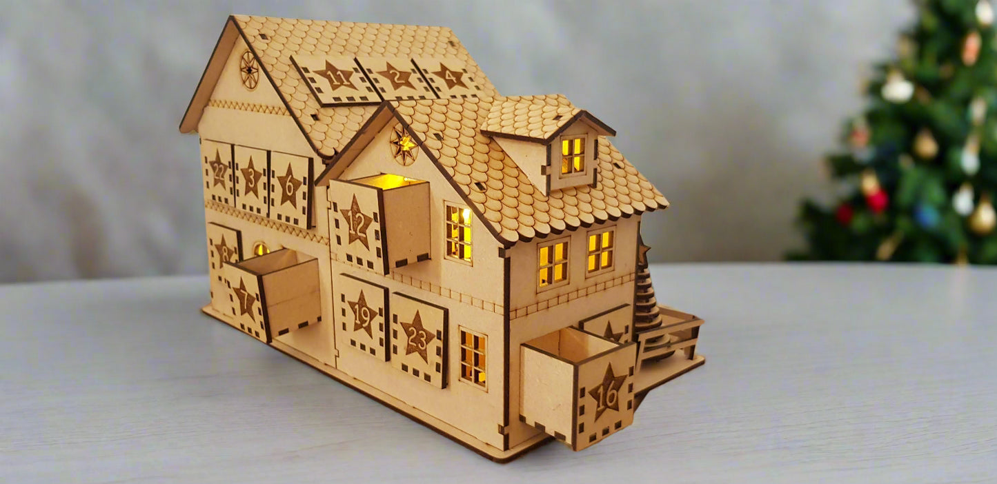 Wooden model house with lit windows on a wooden surface