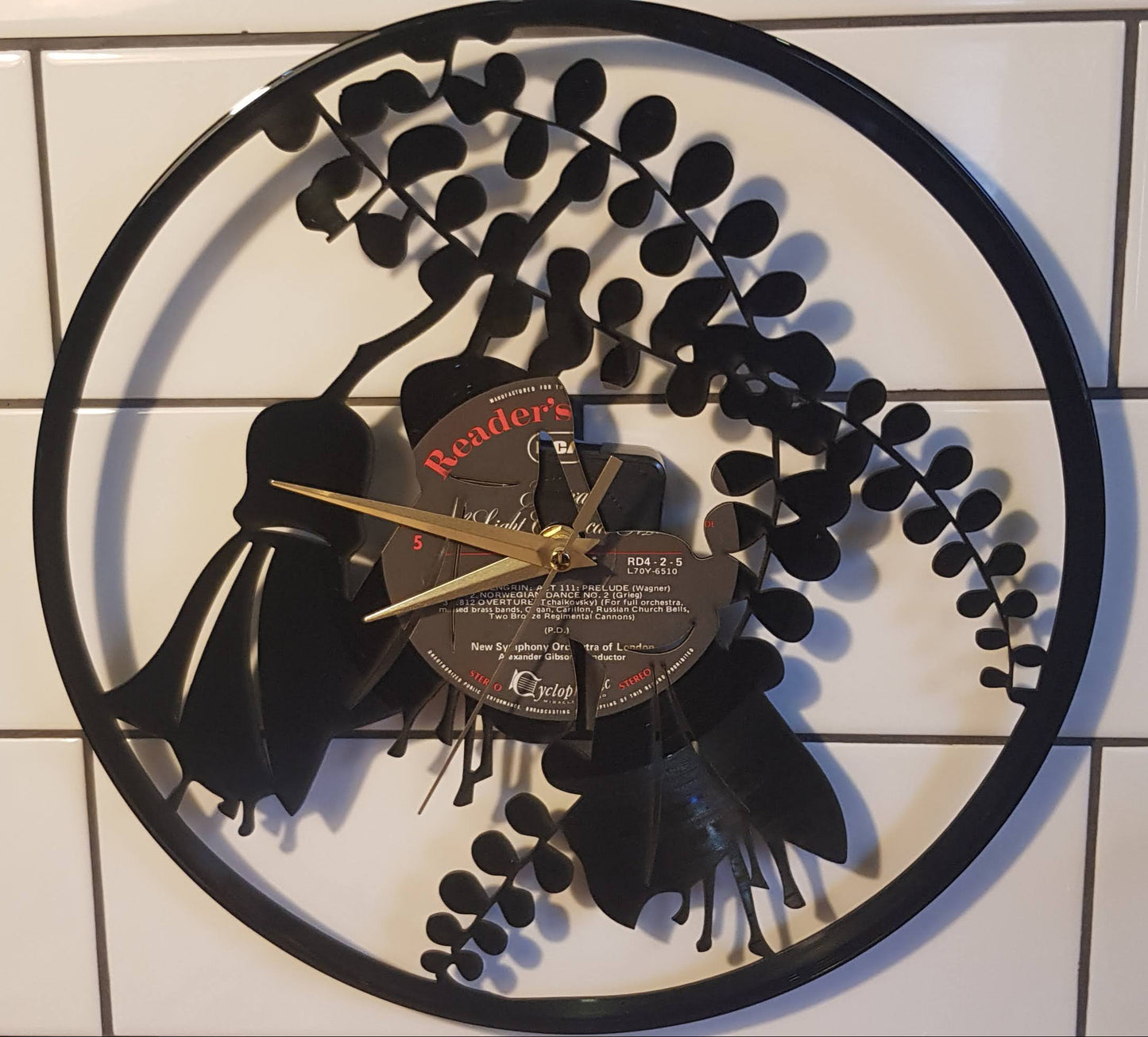 Decorative wall clock made from a vinyl record on a tiled floor