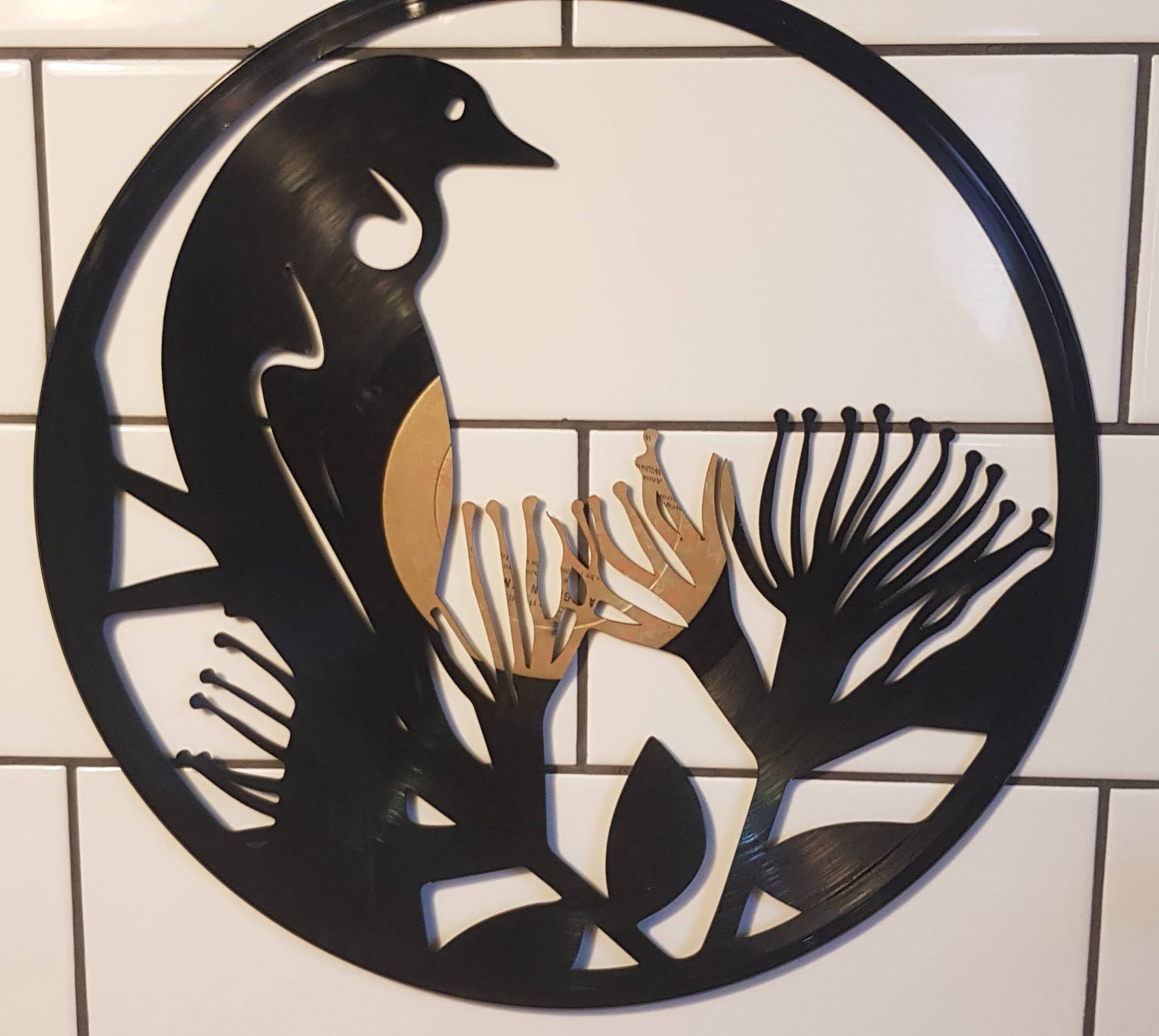 Decorative metal wall art with fish design on a tiled floor