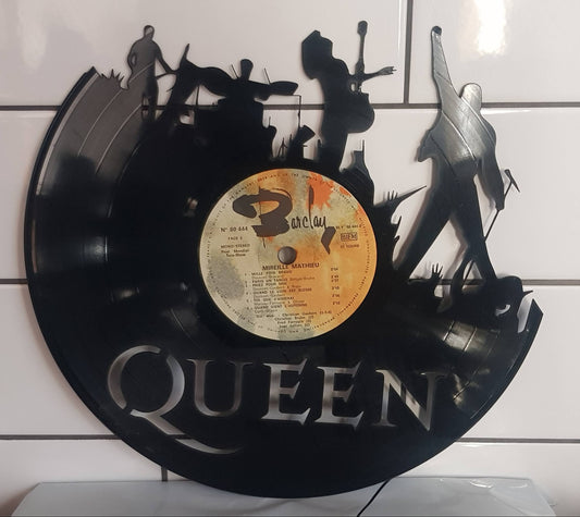 Vinyl record wall art with 'Queen' band members on a white tiled wall.