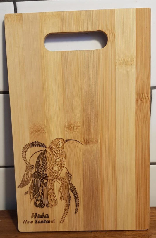Wooden cutting board with a engraved design and text on a tiled wall background