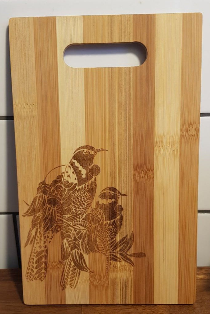 Wooden cutting board with bird engraving on a tiled wall background
